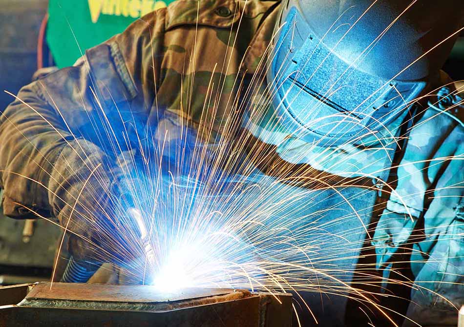 welder working with electrode at semi-automatic arc welding in manufacture production plant